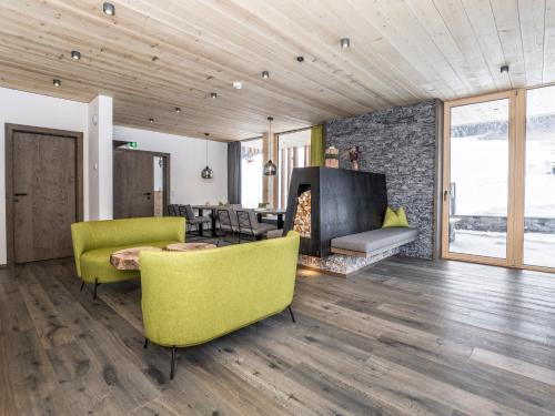a living room with yellow chairs and a fireplace at Appartementhaus Anna Katharina in Fieberbrunn