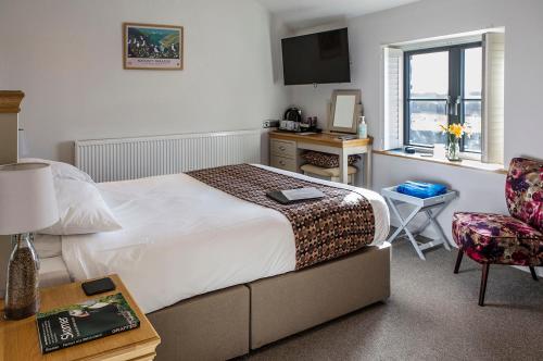 a bedroom with a bed and a desk and a chair at Victoria Inn Brewhouse B&B in Roch