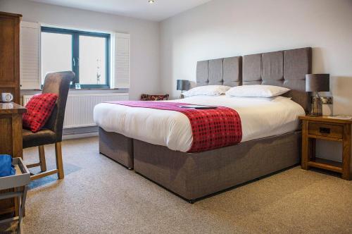 a bedroom with a large bed and a chair at Victoria Inn Brewhouse B&B in Roch