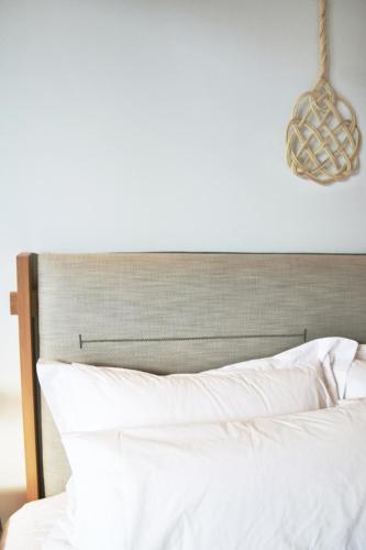 a bedroom with a white bed with a wooden headboard at IADES suites in Afitos