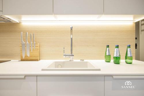 una cucina con lavandino e 2 bottiglie sul bancone di Apartament Baltic Dune z dostępem do basenów,jacuzzi,strefy saun - Pinea Apartments Pobierowo-SANNEL Apartments for rent a Pobierowo