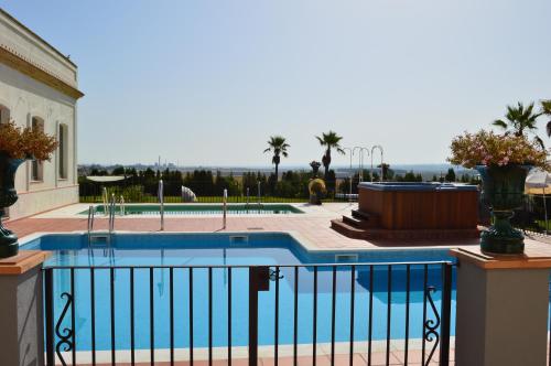 a swimming pool in front of a house at Hacienda Montija Hotel in Huelva