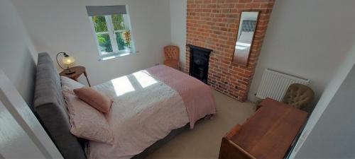 ein Schlafzimmer mit einem Bett und einem Kamin in der Unterkunft Tor Cottage, perfectly positioned! in Glastonbury