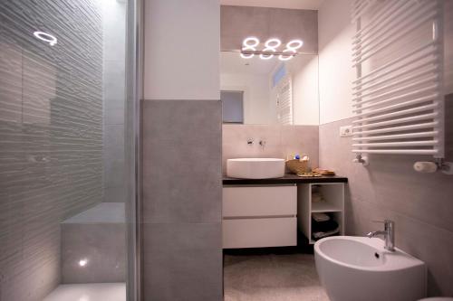 bagno con doccia, lavandino e servizi igienici di GetTheKey Monte Ceneri a Milano