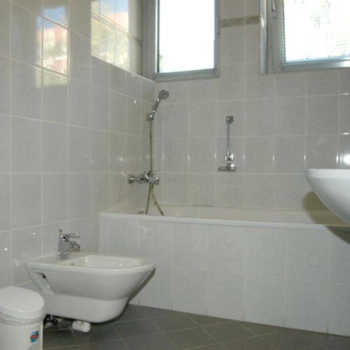 a bathroom with a tub and a toilet and a sink at Kék Hold Hotel in Marcali