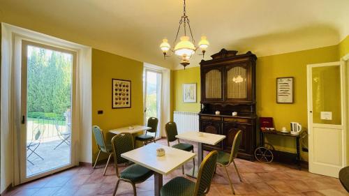 une salle à manger avec des tables et des chaises ainsi qu'un lustre dans l'établissement B&B Villa Dei Priori, à Monsampolo del Tronto