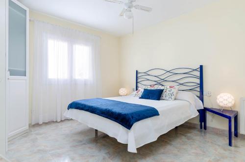 a bedroom with a blue and white bed with a blue blanket at YourHouse Germanor, quiet beach house in Majorca North in Son Serra de Marina