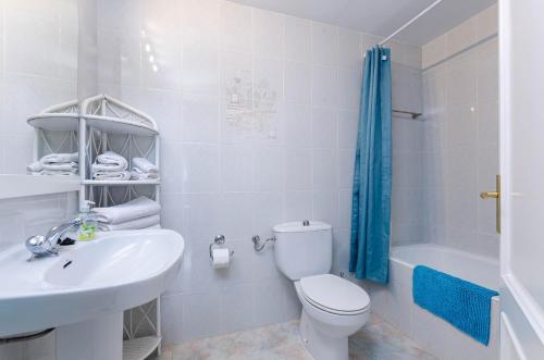 a white bathroom with a toilet and a sink at YourHouse Germanor, quiet beach house in Majorca North in Son Serra de Marina