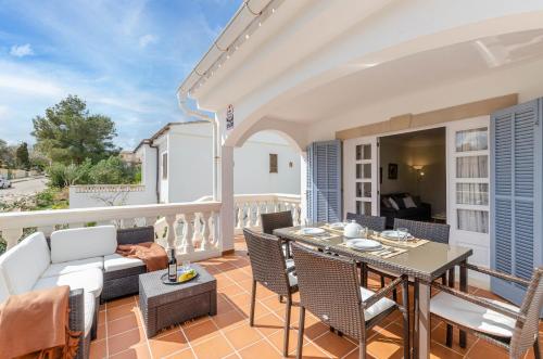 un patio con tavolo e sedie sul balcone. di YourHouse Germanor, quiet beach house in Majorca North a Son Serra de Marina