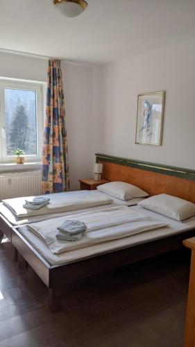 un grande letto in una stanza con due finestre di Residenzpark Willingen Haus Langenberg a Willingen