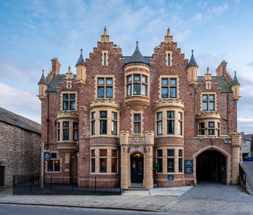a large red brick building with an arch doorway at The Fleece Hotel Richmond in Richmond