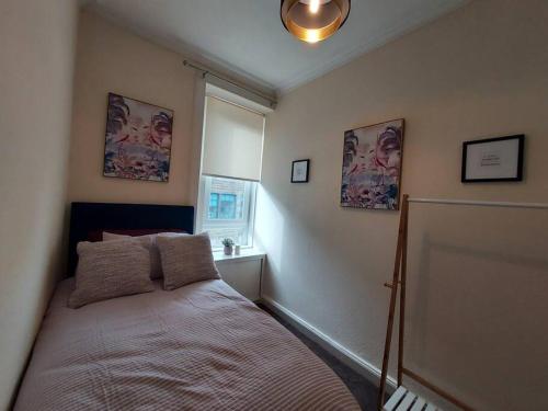 霍伊克的住宿－Lovely 2 bedroom apartment in the centre of Hawick，一间卧室设有一张床和一个窗口