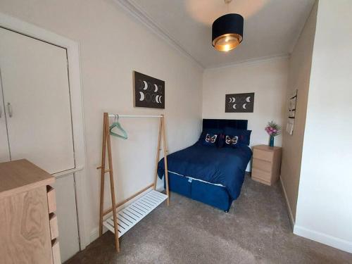 a bedroom with a blue bed in a room at Lovely 2 bedroom apartment in the centre of Hawick in Hawick