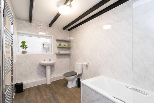 a bathroom with a toilet and a sink and a tub at ✰Excellent 3 bedroom House - Close To Airport in Castle Donington