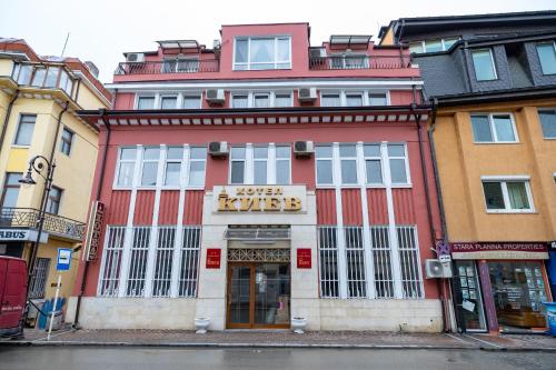 a red and white building on a city street at Hotel Kiev in Veliko Tŭrnovo