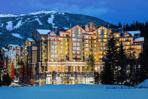 a large building in the mountains with snow on the ground at The Westin Resort & Spa, Whistler in Whistler