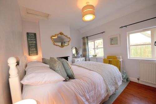Schlafzimmer mit einem Bett mit weißer Bettwäsche und Kissen in der Unterkunft Victoria Cottage, Ironbridge in Ironbridge