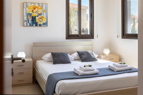 een slaapkamer met een bed met handdoeken erop bij Protaras Villa Angela Nefeli in Paralimni