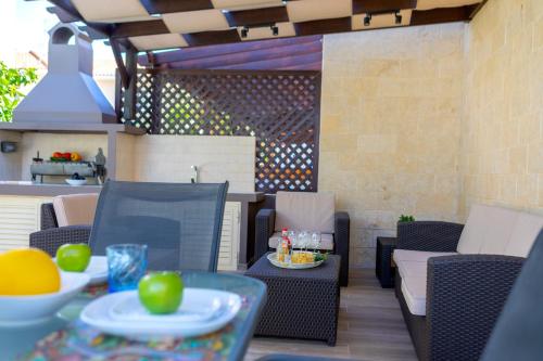 a patio with chairs and a table with food on it at Protaras Villa Angela Nefeli in Paralimni