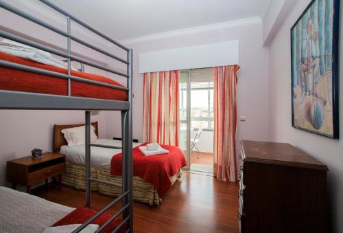 a bedroom with two bunk beds and a window at VistaoMar in São João do Estoril