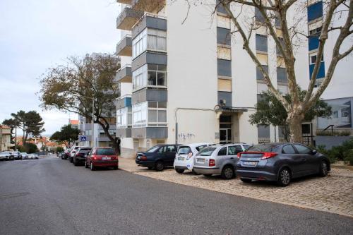 a row of cars parked in front of a building at VistaoMar in São João do Estoril