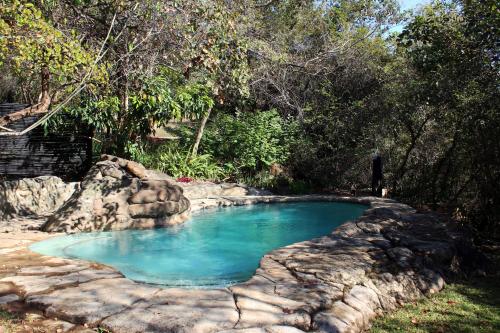 a pool of blue water in a yard at Thulamela Couples Retreat in Hazyview