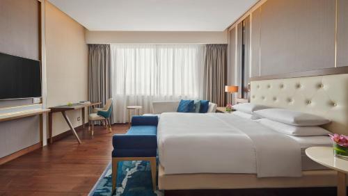 a hotel room with a large bed and a tv at Grand Hyatt Al Khobar Hotel and Residences in Al Khobar