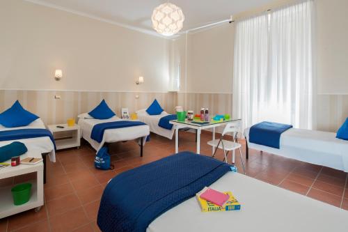 a room with three beds and a table and a bed at Budget Rooms Des Arts in Rome