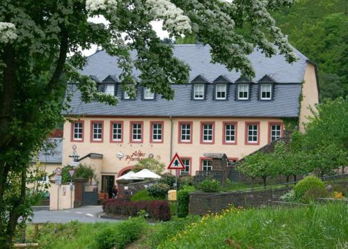 un grand bâtiment rose avec un toit noir dans l'établissement Altes Pfarrhaus, 