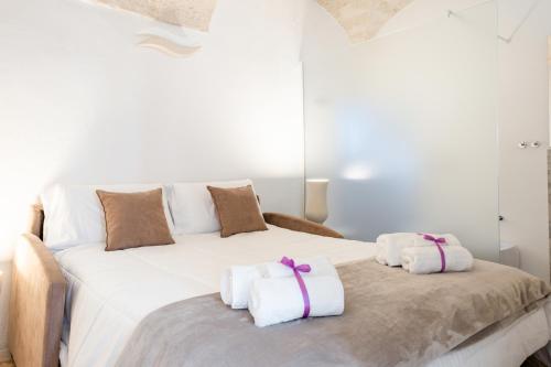 a bedroom with a white bed with towels on it at Palazzo Rapanà - Luxury Apt with hydromassage pool in Ostuni