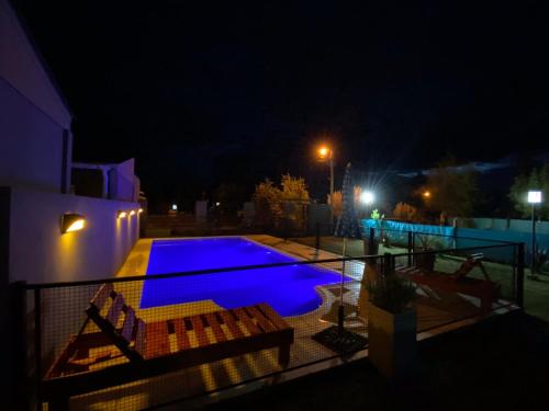 a swimming pool at night with two chairs next to it at Un lugar en Monte in San Miguel del Monte