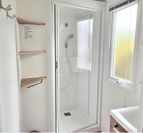 une douche avec une porte vitrée dans une salle de bain dans l'établissement Mobil home 3 chambres, à Saint-Jean-de-Monts