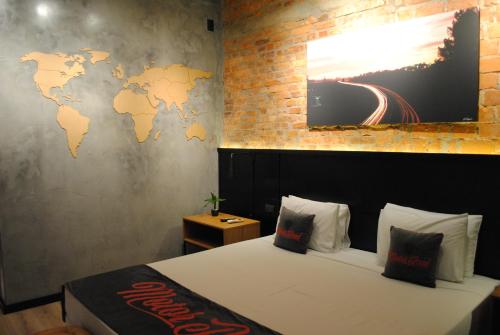 a room with a bed with a map on the wall at Planalto Select Hotel Ponta Grossa in Ponta Grossa