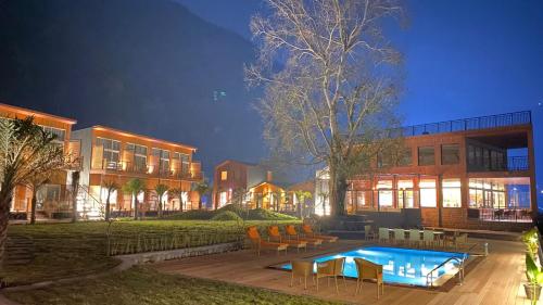 um edifício com piscina em frente a um edifício em juSTa Rasa Retreat & Spa Rishikesh em Bijni