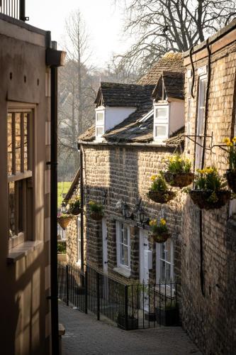 an old brick house with flowerpots on the facade at The Bull And Swan in Stamford