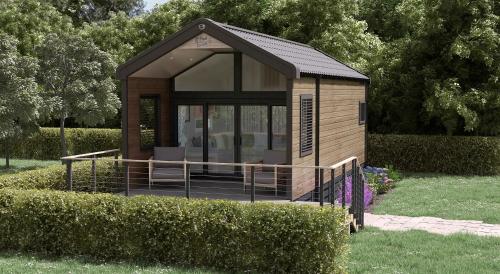 een klein gebouw met een veranda in een tuin bij The Parr Pod - Beautiful, luxury pod in Aberlour