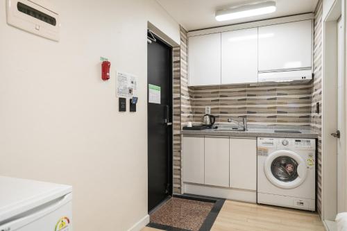 a kitchen with a washing machine and a sink at Malu Hotel Suwon in Suwon