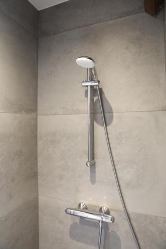 a shower with a shower head in a bathroom at Sfeervol vakantiehuis in centrum Yerseke in Yerseke