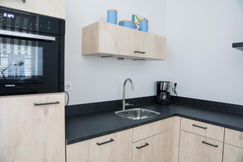 a kitchen with a sink and a microwave at Sfeervol vakantiehuis in centrum Yerseke in Yerseke