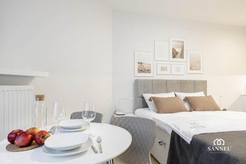 una camera con un letto e un tavolo con piatti e bicchieri di Apartament Baltic Dune z dostępem do basenów,jacuzzi,strefy saun - Pinea Apartments Pobierowo-SANNEL Apartments for rent a Pobierowo