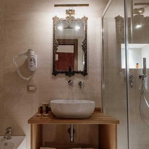 a bathroom with a sink and a shower at Palazzo Giunta - Porta Marina Ortigia in Siracusa