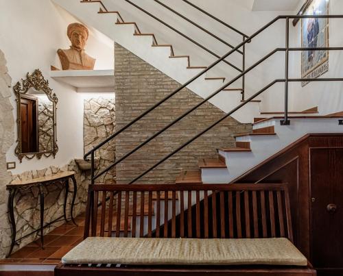 a staircase in a house with a statue on the wall at Palazzo Giunta - Porta Marina Ortigia in Siracusa