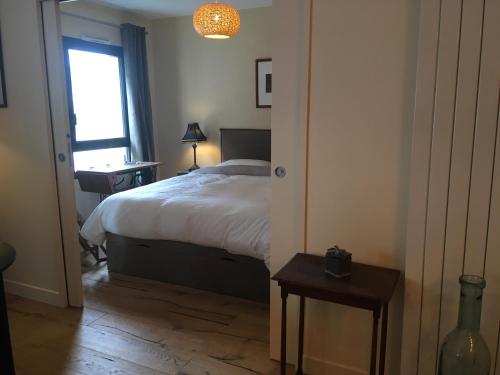 une chambre avec un lit, une fenêtre et une table dans l'établissement LE MONTAIGNE, à La Rochelle