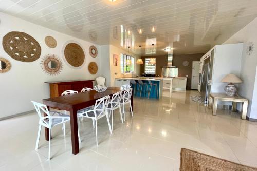a kitchen and dining room with a table and chairs at Villa Maramatea vast modern and comfy leisure and chill out in Moorea in Vaianae