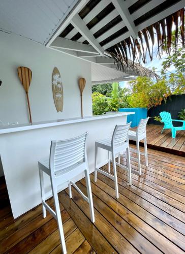 a bar with white chairs and a counter on a deck at Villa Maramatea vast modern and comfy leisure and chill out in Moorea in Vaianae