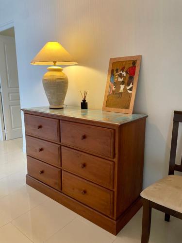 a lamp on top of a dresser with a picture at Villa Maramatea vast modern and comfy leisure and chill out in Moorea in Vaianae