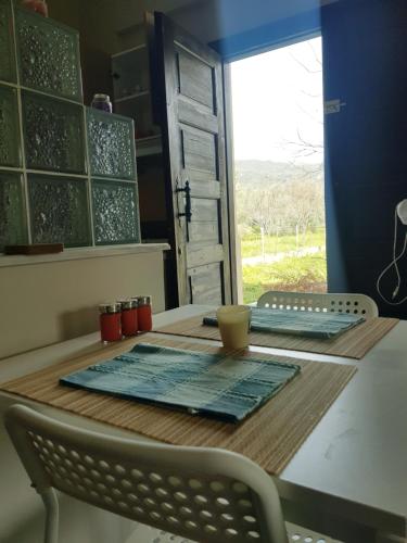 una mesa en una cocina con ventana, mesa y sillas en Small Sunset View apartment, en Áfissos