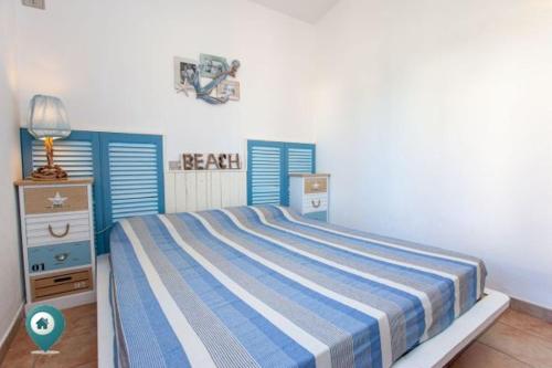 1 dormitorio con 1 cama y ventanas con persianas azules en Villino Asfodeli, en San Teodoro