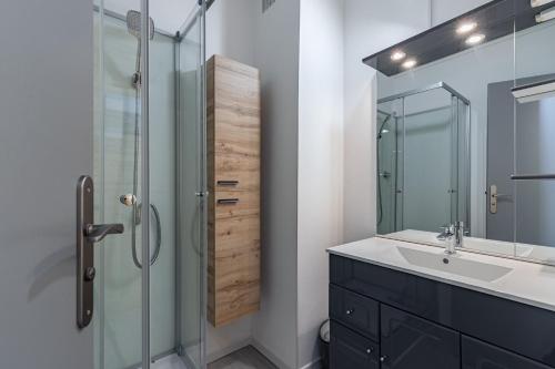 une salle de bain avec une douche en verre et un lavabo dans l'établissement À 600m de la plages des Becs, appartement pour 2, à La Parée Preneau