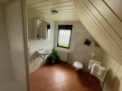 La salle de bains est pourvue d'un lavabo, de toilettes et d'un miroir. dans l'établissement Pension Riegler, à Nossen